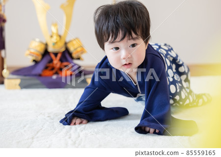 First clause: A boy sitting in front of a helmet 85559165