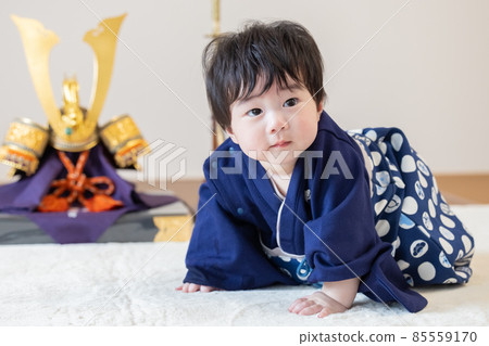 First clause: A boy sitting in front of a helmet 85559170
