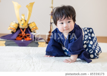 First clause: A boy sitting in front of a helmet 85559173