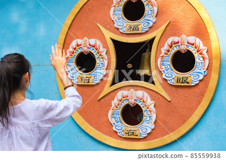 Girl throwing coins for luck at Chinese Buddhist temple in Beijing, China Girl throwing coins for luck at Chinese Buddhist temple in Beijing, China 85559938