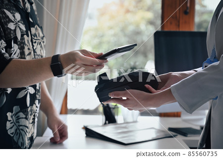 Customer using smart phone scanning for contactless payment at coffee shop. Customer using smart phone scanning for contactless payment at coffee shop. 85560735