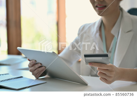 Smiling businesswoman making banking online or shopping online with digital tablet. Smiling businesswoman making banking online or shopping online with digital tablet. 85560736