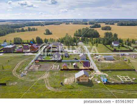 Aerial view of a cottage settlement under construction among the fields in Siberia in summer Aerial view of a cottage settlement under construction among the fields in Siberia in summer 85561907