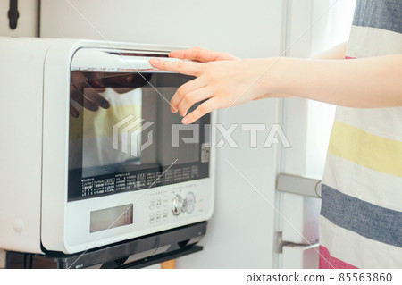 Female using a microwave (without face) 85563860