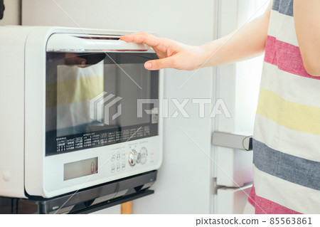Female using a microwave (without face) 85563861