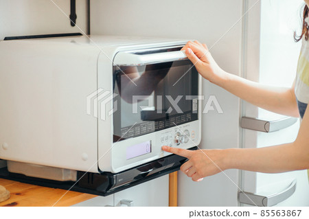 Female using a microwave (without face) 85563867