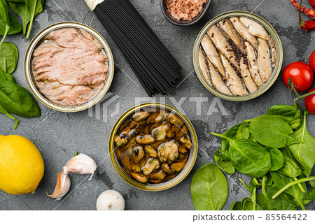 Opened cans with sardines, mussel, tuna, on gray stone table background, top view flat lay 85564422