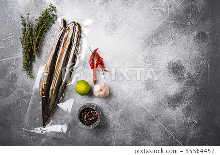 Smoked lamprey vacuum pack, on gray stone table background, top view flat lay, with copy space for text 85564452