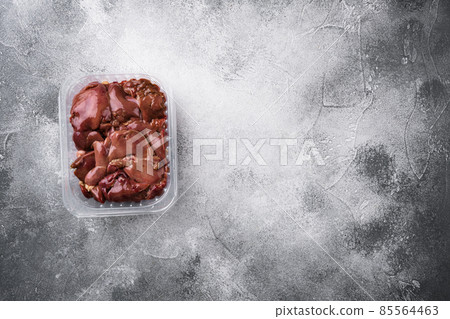 Fresh turkey industrial production, farm turkey liver in a vacuum, on gray stone table background, top view flat lay, with copy space for text Fresh turkey industrial production, farm turkey liver in a vacuum, on gray stone table background, top view flat lay, with copy space for text 85564463