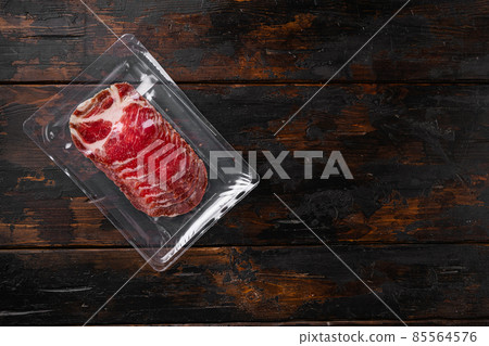 Sliced Ham Salami coppa plastic pack, on old dark wooden table background, top view flat lay, with copy space for text 85564576