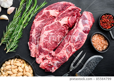 Legendary Ribeye fresh raw beef steak with spices and white beans, on black stone background, top view flat lay Legendary Ribeye fresh raw beef steak with spices and white beans, on black stone background, top view flat lay 85564799