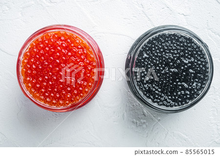 Glass jars with black and red caviar, on white background, top view flat lay Glass jars with black and red caviar, on white background, top view flat lay 85565015