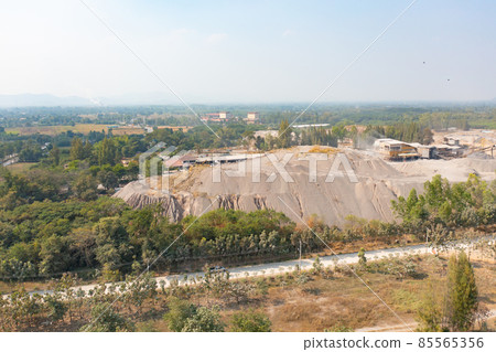 Aerial view of machine excavator trucks dig coal mining or ore with black grunge stone on ground in quarry with mountain hills. Nature landscape background in factory industry. Environment resources 85565356