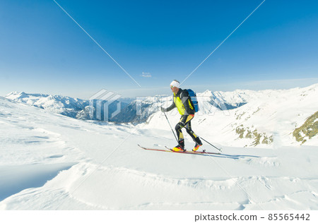 A ski mountaineer climbs with sealskins under his skis 85565442