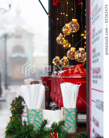 Red pots with mulled wine on Christmas market illuminated stall. Seasonal holiday street food beverages concept New year 85565474