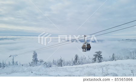 Empty white red closed ski lift cabin no people and white dramatic snowy mountains background. End of season concept. Ski resorts closure Empty white red closed ski lift cabin no people and white dramatic snowy mountains background. End of season concept. Ski resorts closure 85565866