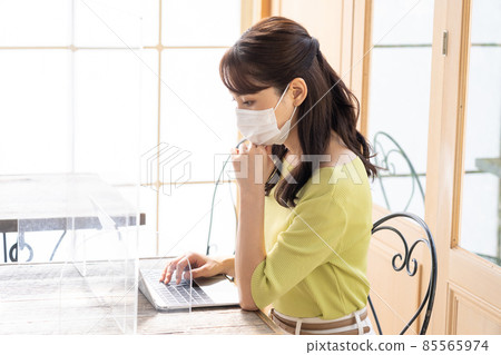 在個人電腦上工作以防止電暈飛沫感染的年輕女性（企業） 85565974