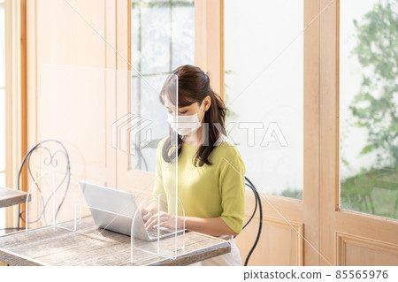 在個人電腦上工作以防止電暈飛沫感染的年輕女性（企業） 85565976