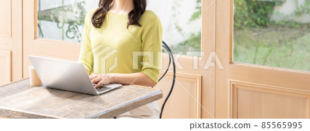 Young woman (business) working at a cafe using a computer Young woman (business) working at a cafe using a computer 85565995