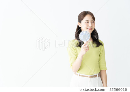 Young women who cool down with a handy fan ・ Measures against heat stroke 85566016