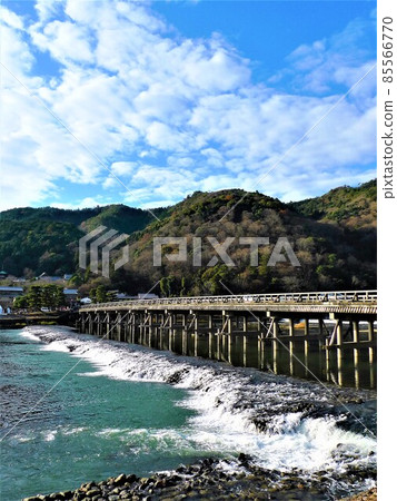 藍天、白雲和嵐山倒映在渡月橋和木樁之間的河流中。 藍天、白雲和嵐山倒映在渡月橋和木樁之間的河流中。 85566770