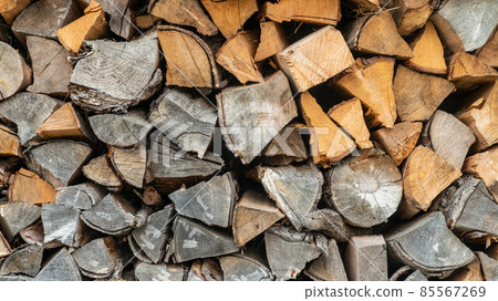 Cut wood logs stored in a storage yard. This woodpile are chopped and saved to burn in a stove during winter. Cut wood logs stored in a storage yard. This woodpile are chopped and saved to burn in a stove during winter. 85567269