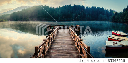 Wooden pier in Savsat Karagol Black lake in Eastern Black Sea region with morning evaporation. Savsat Karagol lake is a large trout lake in the forest in Artvin, Turkey 85567336