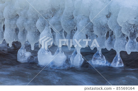 Icicles at winter, cold weather with icicles over river stream Icicles at winter, cold weather with icicles over river stream 85569164