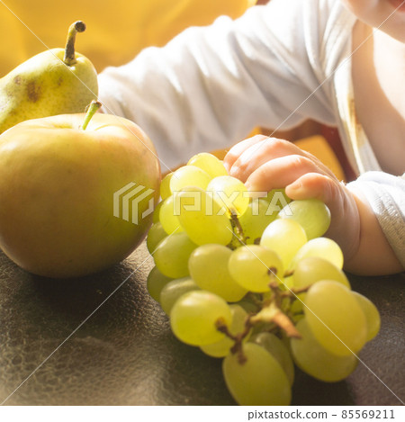 a child plays with a pear a child plays with a pear 85569211