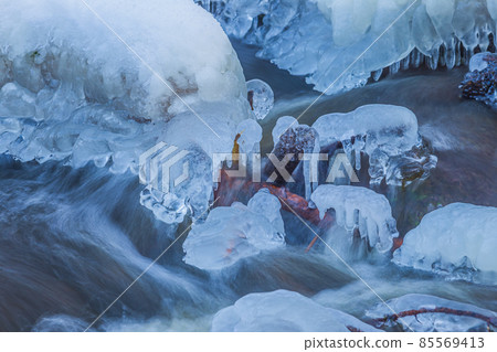 Icicles at winter, cold weather with icicles over river stream Icicles at winter, cold weather with icicles over river stream 85569413