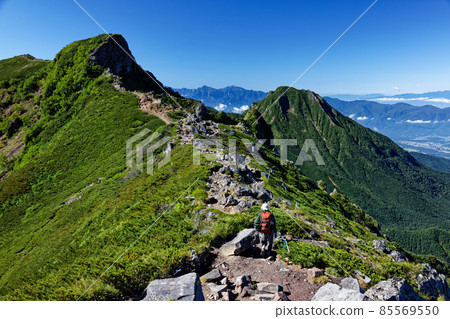 Climbers going along the Yatsugatake mountain range and Yokodake ridgeline and views of Mt. Amida and the Southern Alps Climbers going along the Yatsugatake mountain range and Yokodake ridgeline and views of Mt. Amida and the Southern Alps 85569550