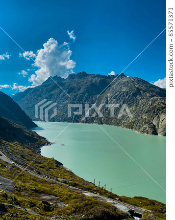 Green lake in Swiss Alps in sunny day Green lake in Swiss Alps in sunny day 85571371