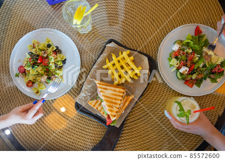 top view portrait of two young woman having lunch together at cafe. top view portrait of two young woman having lunch together at cafe. 85572600