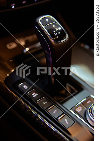 Automatic gear stick of a modern car, multimedia and navigation control buttons. Car interior details. Transmission shift. Shallow dof 85573253