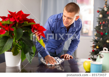 Man wipes the table before Christmas Man wipes the table before Christmas 85573437