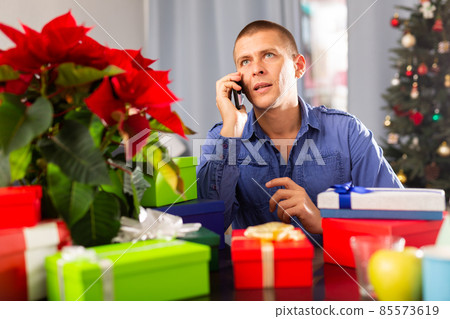 Man with boxes of christmas gifts at home Man with boxes of christmas gifts at home 85573619