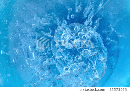Frozen iced water in macro pattern. Light violet blue abstract natural composition. Color 2022. Cold water with air bubbles.  85573953