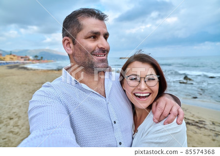Happy mature couple taking selfie photo on smartphone. 85574368
