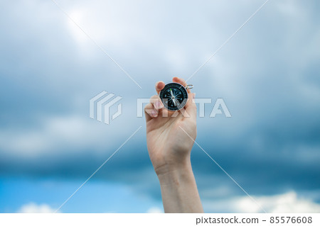 Traveler hand holds a compass on the beautiful Carpathian mountains view. Horizontal banner with place for text. Vacation and travel. 85576608