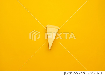 Piece of tasty cream cheesecake on yellow background Piece of tasty cream cheesecake on yellow background 85576611