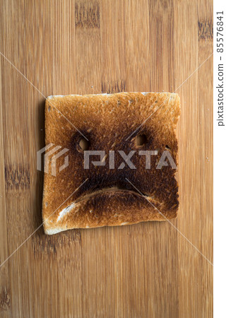 Closeup of expressive toasted slices of bread on wooden cutting board background Closeup of expressive toasted slices of bread on wooden cutting board background 85576841