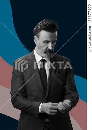 Black and white portrait of a stylish elegant senior businessman with a beard and casual business clothes against retro colorful pattern design background gesturing with hands Black and white portrait of a stylish elegant senior businessman with a beard and casual business clothes against retro colorful pattern design background gesturing with hands 85577100