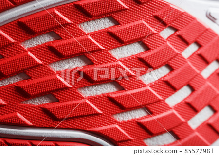 Running shoes with red soles on a black background. 85577981