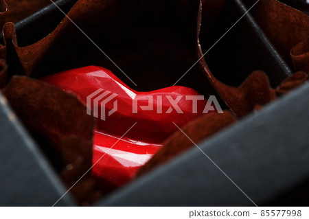 Exquisite handmade chocolate candy in the shape of red lips close-up Exquisite handmade chocolate candy in the shape of red lips close-up 85577998