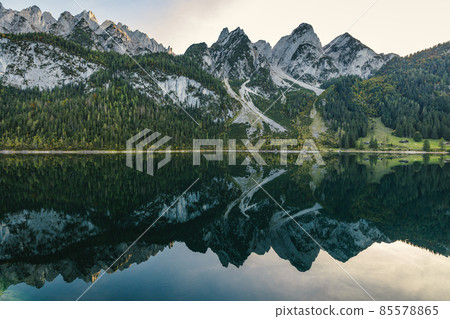Beautiful view of idyllic colorful autumn scenery with Dachstein mountain summit reflecting in crystal clear Gosausee mountain lake in fall, Salzkammergut region, Upper Austria. Beautiful view of idyllic colorful autumn scenery with Dachstein mountain summit reflecting in crystal clear Gosausee mountain lake in fall, Salzkammergut region, Upper Austria. 85578865