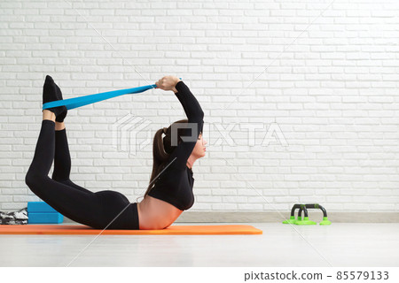 the girl conducts a home workout stretching to strengthen her back 85579133