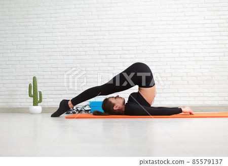 the girl conducts a home workout stretching to strengthen her back 85579137