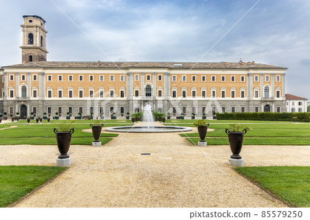 Turin, Italy, garden and park with a fountain, vases of flowers, the building of the royal palace, in the background the bell tower of the Turin cathedral. Turin, Italy, garden and park with a fountain, vases of flowers, the building of the royal palace, in the background the bell tower of the Turin cathedral. 85579250