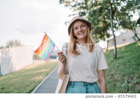 Beautiful caucasian lesbian woman with LGBT flag, celebrating gay pride outdoors. Pride festival concept Beautiful caucasian lesbian woman with LGBT flag, celebrating gay pride outdoors. Pride festival concept 85579401