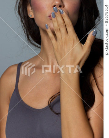 Beauty closeup of brunette lower face with clean skin and evening makeup. The girl looks at the camera and sends an air kiss. Smooth eyebrows and very long eyelashes Beauty closeup of brunette lower face with clean skin and evening makeup. The girl looks at the camera and sends an air kiss. Smooth eyebrows and very long eyelashes 85579514